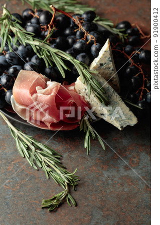 Prosciutto with blue cheese, grapes, and rosemary. 91900412