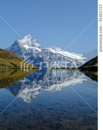 Rocky mountains and reflection on the surface of the lake. Landscape in Grindelwald, Switzerland. the highlands in the summertime 91901727