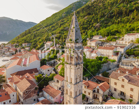 Scenic panorama view of the historic town of Perast at famous Bay of Kotor with blooming flowers on a beautiful sunny day with blue sky and clouds in summer, Montenegro, southern Europe Scenic panorama view of the historic town of Perast at famous Bay of Kotor with blooming flowers on a beautiful sunny day with blue sky and clouds in summer, Montenegro, southern Europe 91902316