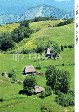 Abandoned summer village with wooden stables and thatched roof 91902679