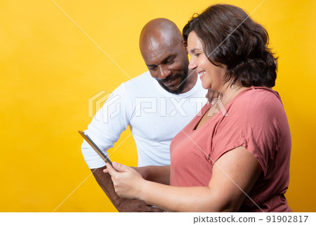 multiracial couple managing technology together multiracial couple managing technology together 91902817