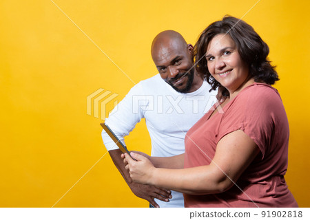 multiracial couple managing technology together  91902818
