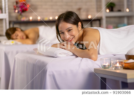 Asian pretty woman lie on bed in front of her friend and also smile to camera during spa massage 91903066
