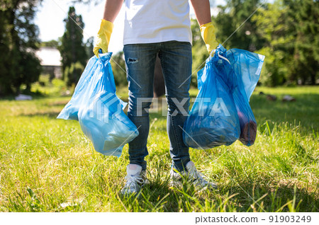 Close up of a person with bags with garbage in hands Close up of a person with bags with garbage in hands 91903249