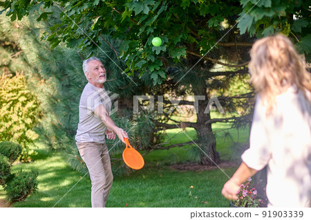 Mature couple looking enjoyed while playing tennis in the park 91903339