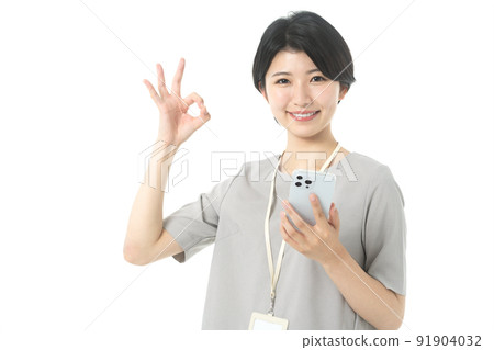 穿著年輕休閒服裝的女工程師操作智能手機(白色背景) 穿著年輕休閒服裝的女工程師操作智能手機(白色背景) 91904032