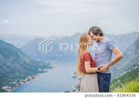 Man and woman couple tourists enjoying the view of Kotor. Montenegro. Bay of Kotor, Gulf of Kotor, Boka Kotorska and walled old city. Travel to Montenegro concept. Fortifications of Kotor is on UNESCO Man and woman couple tourists enjoying the view of Kotor. Montenegro. Bay of Kotor, Gulf of Kotor, Boka Kotorska and walled old city. Travel to Montenegro concept. Fortifications of Kotor is on UNESCO 91904336