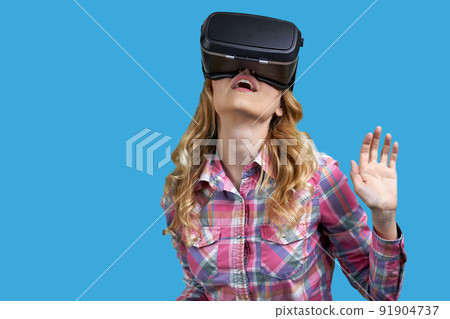Young woman wearing virtual reality headset on color background. Young woman wearing virtual reality headset on color background. 91904737