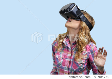 Young casual woman uses virtual glasses on color background. Young casual woman uses virtual glasses on color background. 91904750