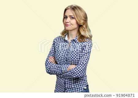 Dissatisfied young woman standing with arms crossed on color background. 91904871