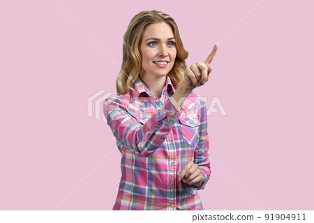 Pretty smiling girl swiping imaginary touch screen on color background. Pretty smiling girl swiping imaginary touch screen on color background. 91904911