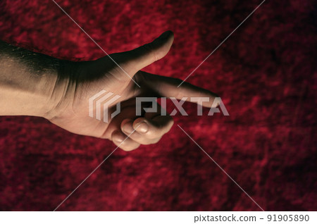 Gesture with index finger. Hand of a mature man against a dark red background. Close-up. Selective focus. Defocus, noise, grain effect. Gesture with index finger. Hand of a mature man against a dark red background. Close-up. Selective focus. Defocus, noise, grain effect. 91905890