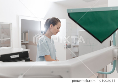 Hospital Radiology Room. Xray machine for fluorography. Doctor radiologist in gown adjusting the X-ray machine for radiography. Medical equipment. Scanning chest, heart or lungs in clinic office. 91908011