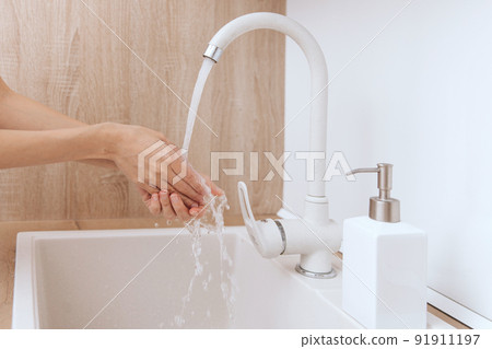 Washing hands under the flowing water tap. Washing hands rubbing with soap for corona virus prevention, hygiene to stop spreading corona virus in or public wash room. Hygiene concept hand detail. Washing hands under the flowing water tap. Washing hands rubbing with soap for corona virus prevention, hygiene to stop spreading corona virus in or public wash room. Hygiene concept hand detail. 91911197