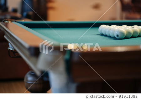Billiard table with green surface and balls in the billiard club. 91911382