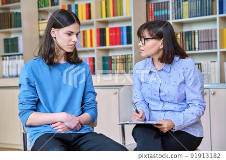 Individual therapy, social worker psychologist working with college student guy in library office Individual therapy, social worker psychologist working with college student guy in library office 91913182