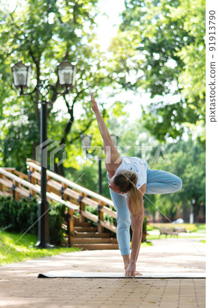 Young man practice yoga in the park. Yoga asanas in city park, sunny day. Concept of meditation, wellbeing and healthy lifestyle Young man practice yoga in the park. Yoga asanas in city park, sunny day. Concept of meditation, wellbeing and healthy lifestyle 91913790