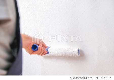A man is painting vinyl wallpaper with velour 91913806