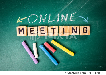 Online Meeting. Wooden alphabet letters and pieces of chalk on a green chalk board Online Meeting. Wooden alphabet letters and pieces of chalk on a green chalk board 91913816