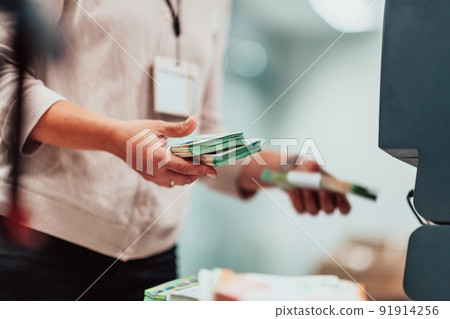 Bank employees holding a pile of paper banknotes while sorting and counting inside bank vault. Large amounts of money in the bank 91914256