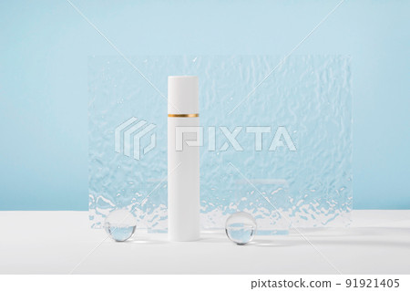 Unbranded cosmetic cream plastic tube mockup on blue background with stylish props, glass balls and acrylic plate. Lotion, concealer or white beauty product packaging. Product presentation 91921405