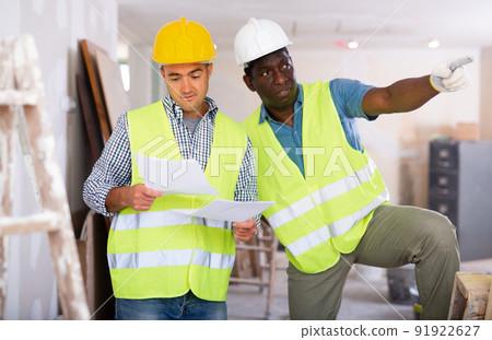 Engineer and architect talking about documents in building site 91922627