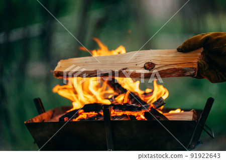 男性露營者（露營）向篝火添加燃料（木柴） 91922643