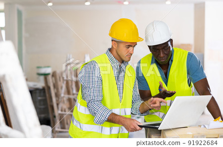 Male engineers using laptop in building site Male engineers using laptop in building site 91922684