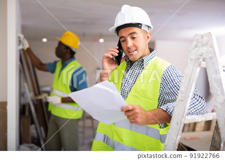 Portrait of foreman talking on phone about project documentation Portrait of foreman talking on phone about project documentation 91922766