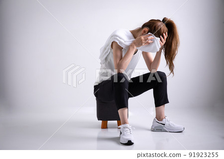 A woman sitting with her head held lose A woman sitting with her head held lose 91923255