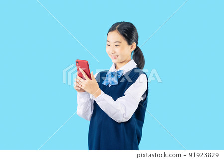 Female student looking at a smartphone Female student looking at a smartphone 91923829