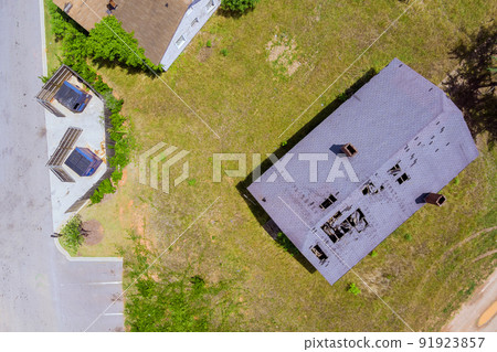 View from the air of roof shingles that have been damaged by high winds and strong storms. View from the air of roof shingles that have been damaged by high winds and strong storms. 91923857