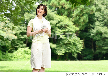 一個女人在樹蔭下使用風扇 一個女人在樹蔭下使用風扇 91923957