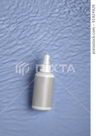 Cosmetic moisturizer with hyaluronic acid, micellar emulsion on blue water background with splashes. Mockup of cosmetic packaging 91924926