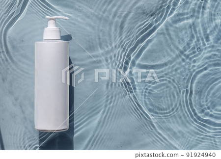 Cosmetic moisturizer with hyaluronic acid, micellar emulsion on blue water background with splashes. Mockup of cosmetic packaging Cosmetic moisturizer with hyaluronic acid, micellar emulsion on blue water background with splashes. Mockup of cosmetic packaging 91924940
