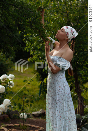 Woman examining branches in garden 91925144