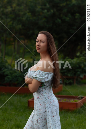 Sensual woman standing in garden Sensual woman standing in garden 91925145