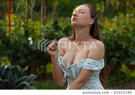 Sensitive woman sitting in garden Sensitive woman sitting in garden 91925146