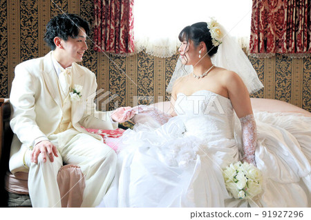 Bride in a wedding dress and groom in white black tie Photo Wedding studio photo, in front of bridal photo 91927296