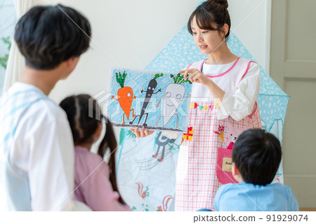 Nursery teacher playing picture-story show Nursery teacher playing picture-story show 91929074