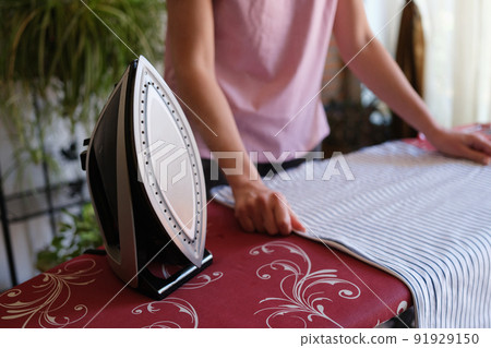 Housewife ironing bed linen on special board Housewife ironing bed linen on special board 91929150