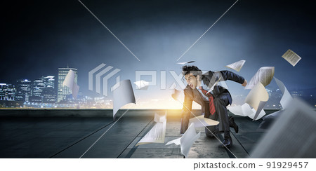 Determined businessman leaving fire trails on asphalt 91929457