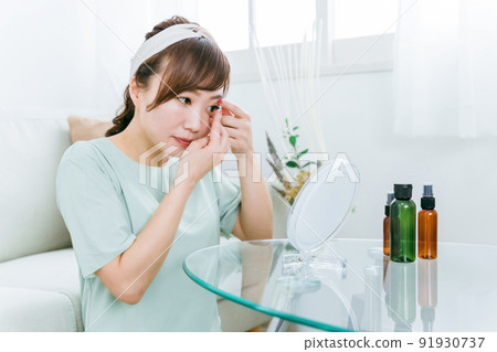 A woman wearing contact lenses at home 91930737