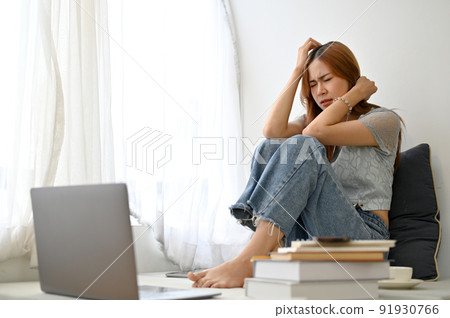 Stressed frustrated young Asian woman sitting in her home living room, depression, crying 91930766