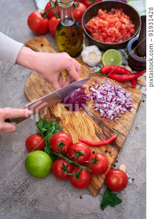 woman cutting and chopping onion by knife on wooden board woman cutting and chopping onion by knife on wooden board 91931428