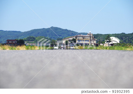 A scene where the scenery is swaying in the heat of the heat in the distance of the asphalt road surface under the scorching sun of summer A scene where the scenery is swaying in the heat of the heat in the distance of the asphalt road surface under the scorching sun of summer 91932395
