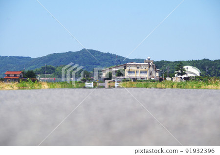 A scene where the scenery is swaying in the heat of the heat in the distance of the asphalt road surface under the scorching sun of summer A scene where the scenery is swaying in the heat of the heat in the distance of the asphalt road surface under the scorching sun of summer 91932396
