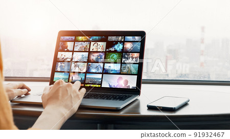 A woman viewing an image library on her computer 91932467
