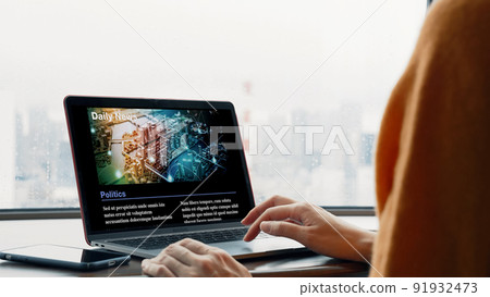 Female viewing online articles on a computer 91932473