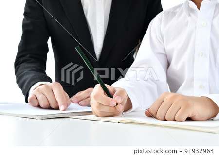 At hand of a child studying and a teacher teaching At hand of a child studying and a teacher teaching 91932963